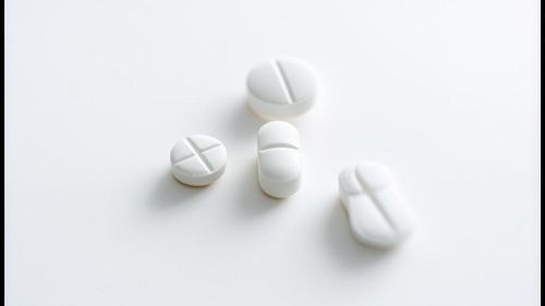 白い台の上に並べられた処方薬の錠剤イメージ